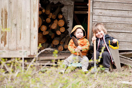 两个小孩坐在小屋附近