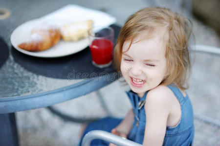 微笑着吃早餐的小女孩
