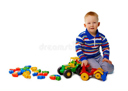 男孩坐在白色背景上拿着玩具