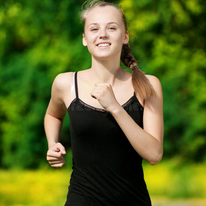 在绿色公园跑步的年轻女子