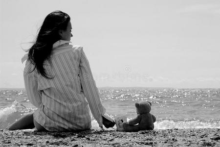 坐在空旷海岸上的年轻女孩