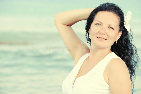 在海边穿着白色太阳裙的女人。