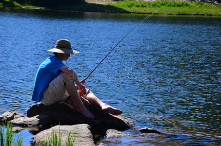 小男孩在湖边钓鱼