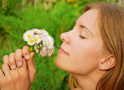 女孩小女孩在夏日的森林里闻到雏菊的香味雏菊花坛上的女孩印度女孩