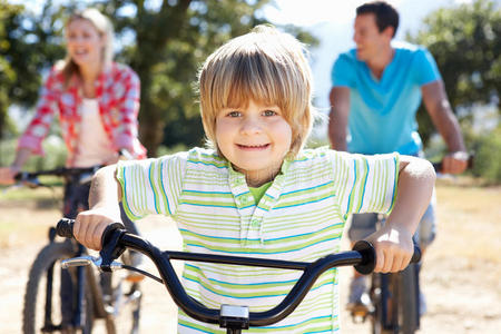 骑自行车穿越乡村的年轻家庭图片
