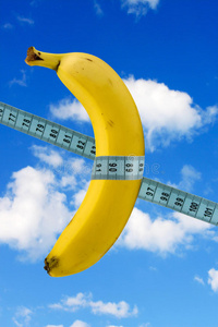 天空背景带卷尺的香蕉