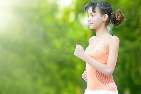 在绿色公园跑步的少女
