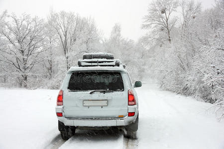 一辆面目全非的汽车后面雪白的冬日公路