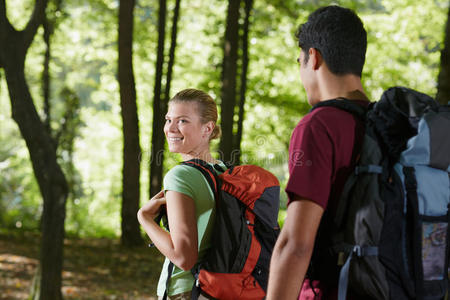 一对背着背包在树林里徒步旅行的夫妇