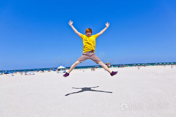 男孩在海滩上跳空