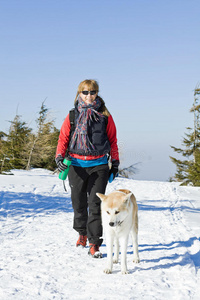 冬天和狗一起徒步旅行的女人