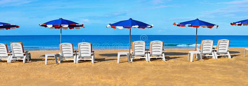 热带海滩上的日光浴床和雨伞
