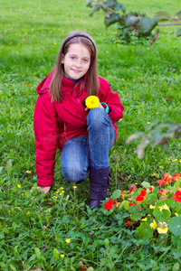 一个女孩在草地上和一朵花摆姿势