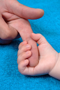 婴儿握着父亲的手指