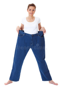 年轻女性穿着旧的大牛仔裤，节食