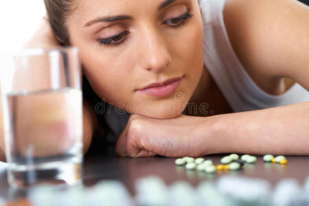 压力和悲伤的黑发女人和一些药片，