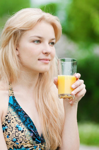 微笑着喝橙汁的女人