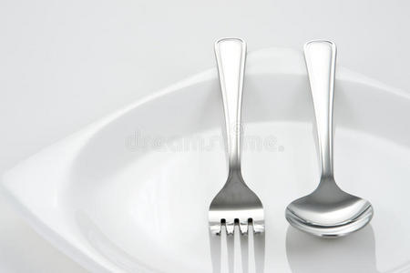 白色盘子上的叉子和勺子