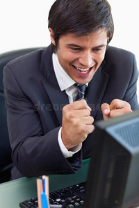 一位兴高采烈的商人用电脑工作的画像
