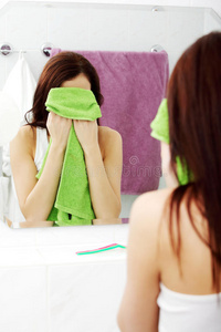 年轻女子用毛巾擦脸。