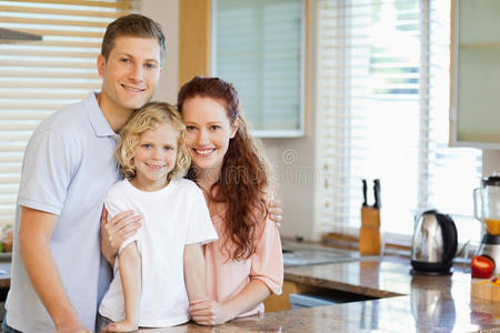 微笑的一家人站在厨房柜台后面图片