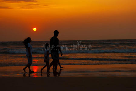 一家人在海边散步的剪影图片