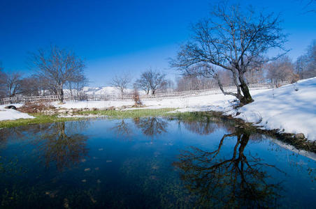 被雪包围的池塘一个冬天的时候,雄性在篝火旁温暖双手,被雪包围在冰湖