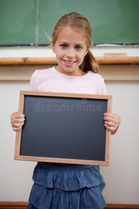 一个年轻女孩拿着学校石板的画像