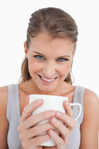 一位微笑的妇女端着一杯茶的画像