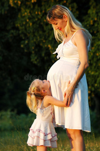 小女孩拥抱一位怀孕的妈妈