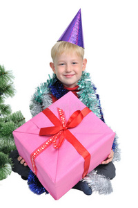 圣诞树旁拿着圣诞礼物的男孩