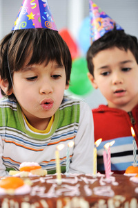 两个小男孩在蛋糕上吹蜡烛
