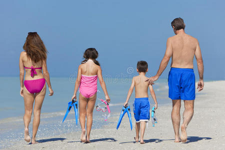 母亲父亲和孩子一家在沙滩上散步