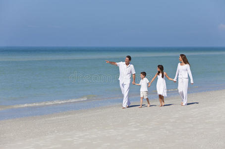 母亲父亲和孩子一家在沙滩上散步