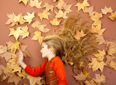 秋天的女孩在干燥的叶子上