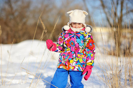 穿着五颜六色雪衣的小女孩在雪地里玩耍