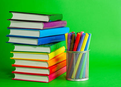 一摞彩色书籍和毛毡笔插座