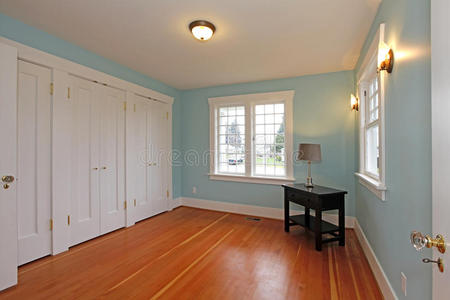 带樱桃色地板和白色壁橱门的蓝色房间