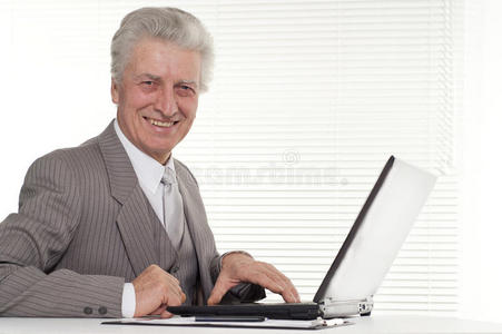 坐在笔记本电脑旁的老人