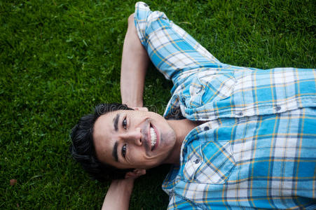 快乐的年轻人躺在草地上