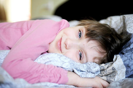 可爱的小女孩在床上放松