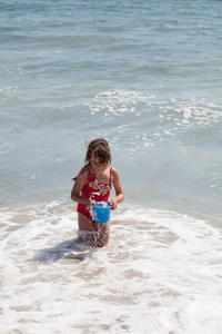 小女孩在沙滩上玩水桶