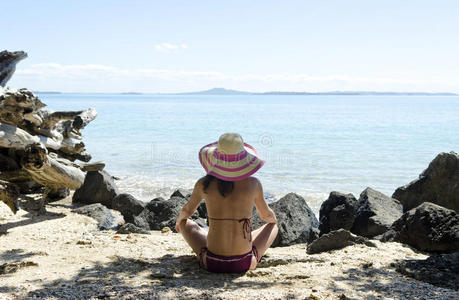 戴帽子坐在沙滩上的女人