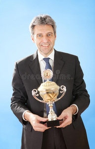 拿着奖杯的高级商人图片