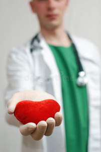 年轻英俊的医生手捧心脏图片