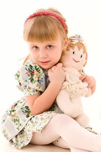 带洋娃娃的快乐小女孩的画像