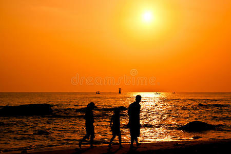 一家人在海滩上散步的剪影图片
