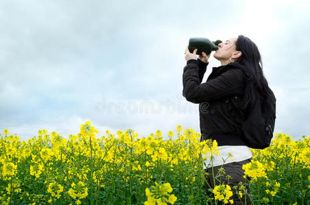 妇女在田里用水瓶喝水