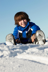 在山上度假的小男孩在雪地里玩耍