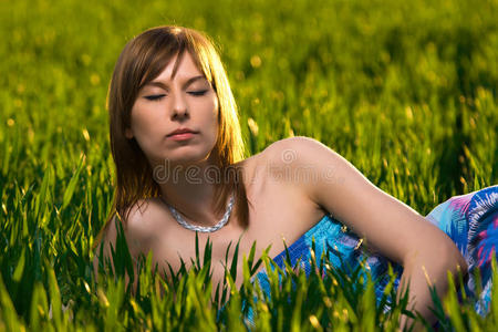 美丽的年轻女子在绿色公园放松